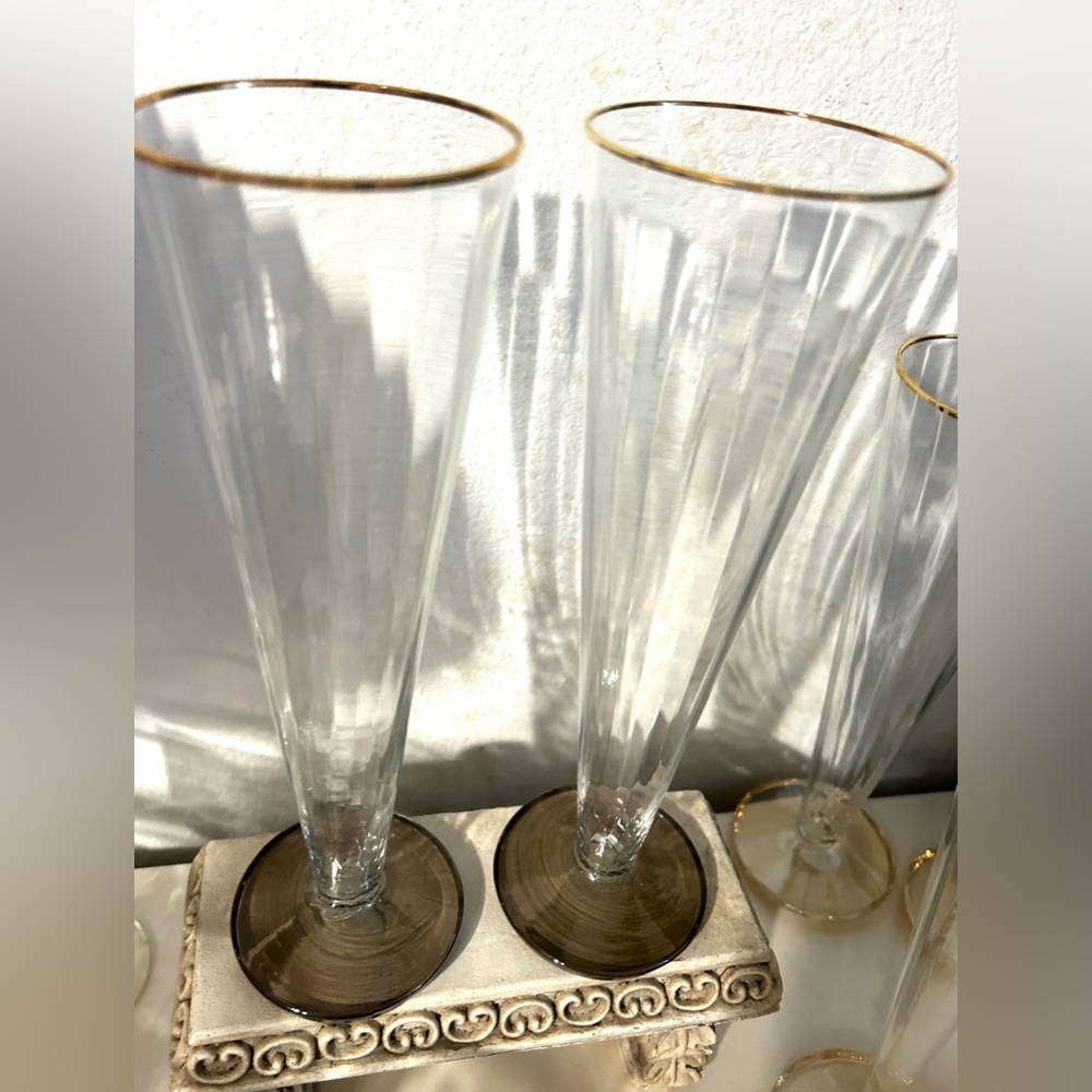 2 tall, gold rimmed, glass champagne flutes with smokey colored foot. 9.5”